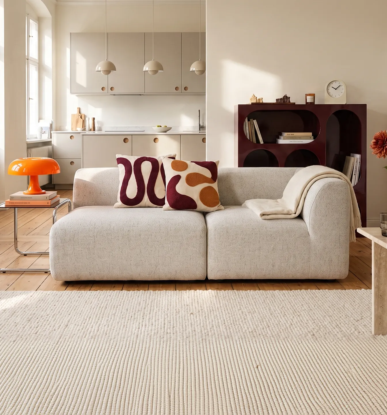 Helles Wohnzimmer mit niedrigem ELIN Sofa, Kissen in Grün und Rot