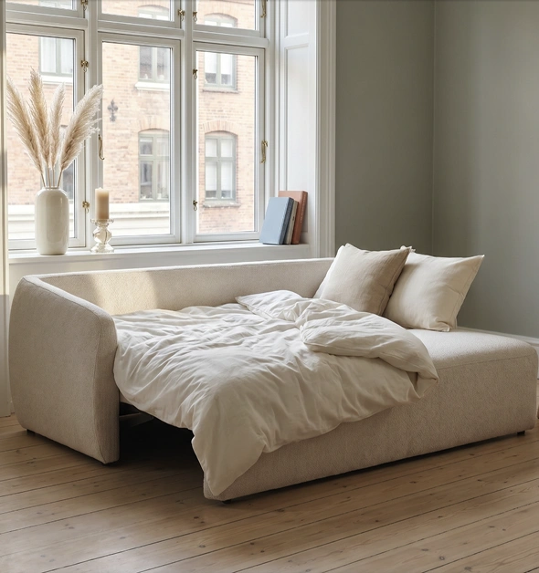 Aufgeklapptes Schlafsofa in hellem Wohnraum