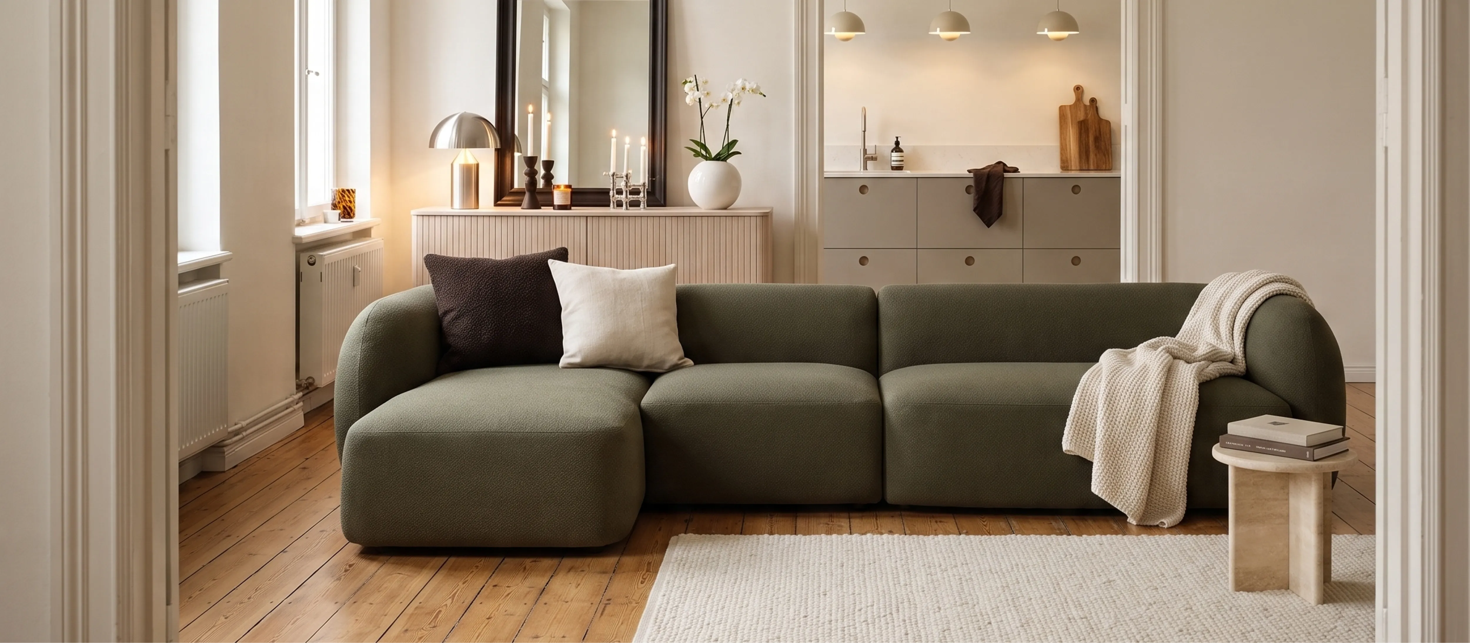 Helles Wohnzimmer mit Sofa in Bouclé, daneben Bezugsmuster in Leder, Samt und Cord