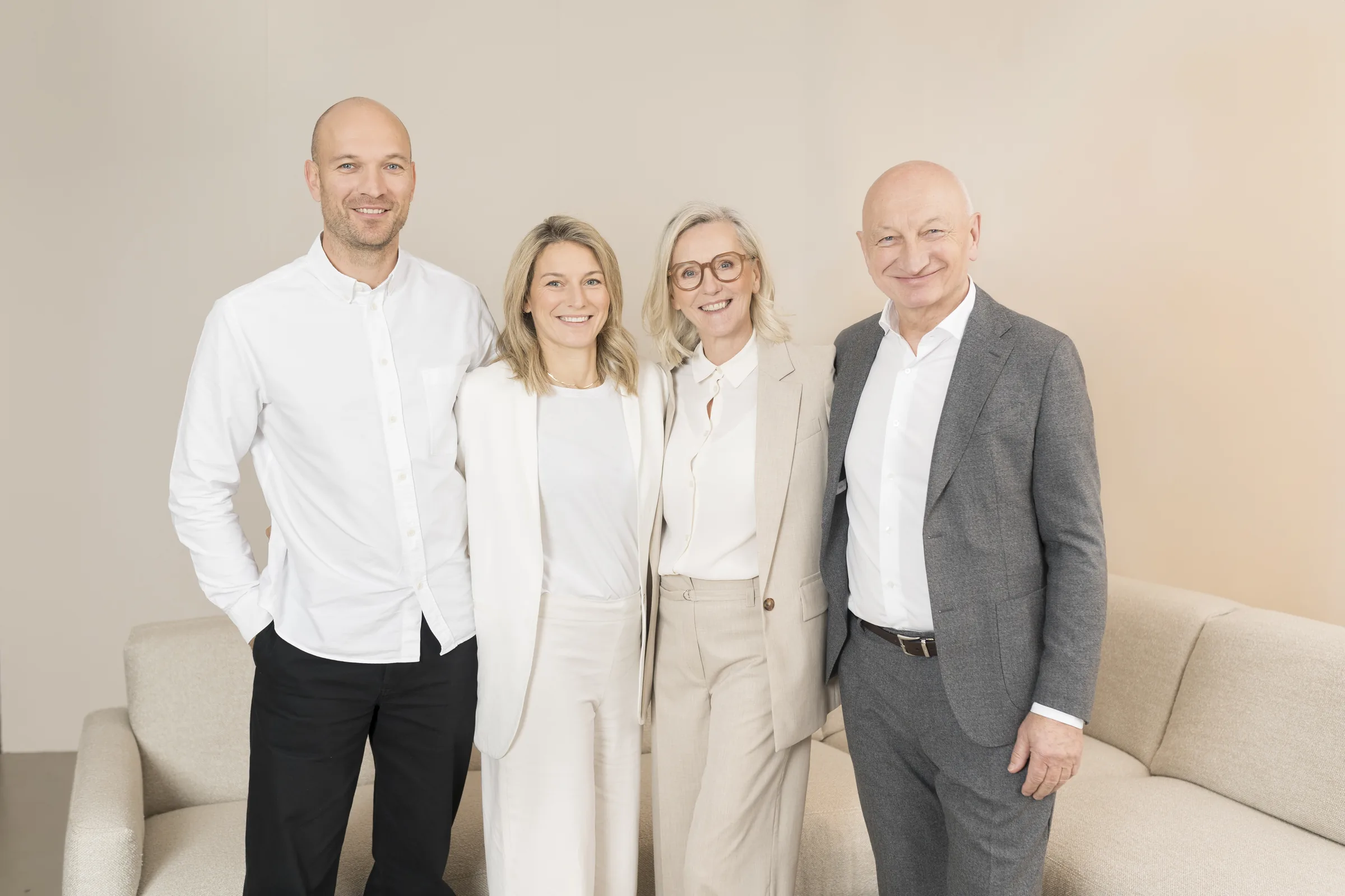 The management team of Möbel Ehrmann in front of a light-coloured sofa